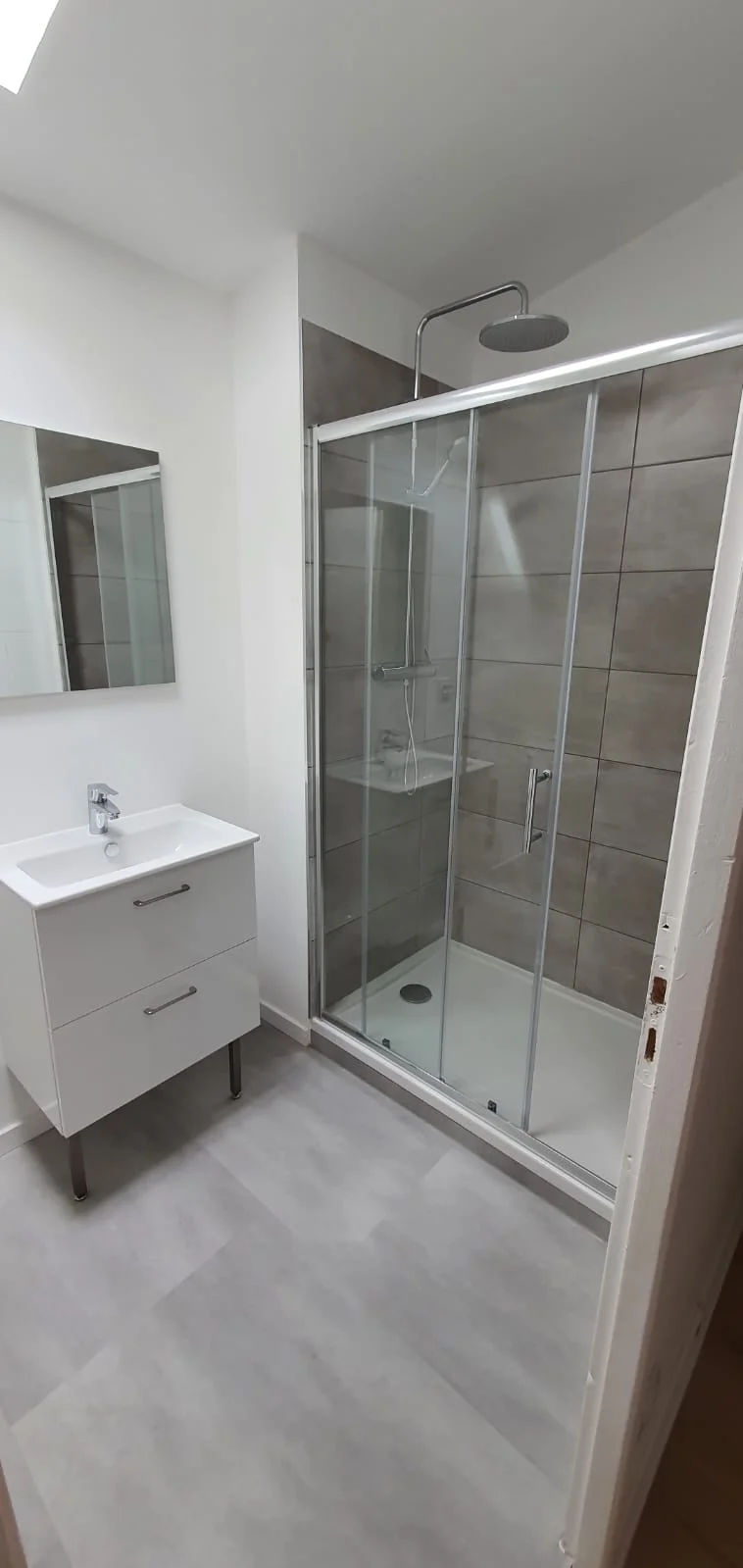 Salle d’eau rénovée avec douche vitrée dans l’immeuble Adrien à Audincourt