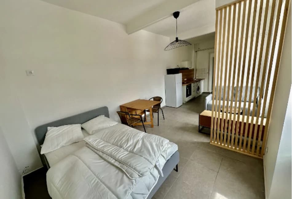 Studio Alexandre rénové à Sochaux avec couchage, table, cuisine et claustra en bois